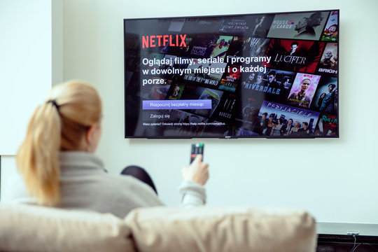 WROCLAW, POLAND - APRIL 03rd, 2018: Woman is using NEtflix application on her TV.Netflix is an american entertainment company specialized in streaming media.