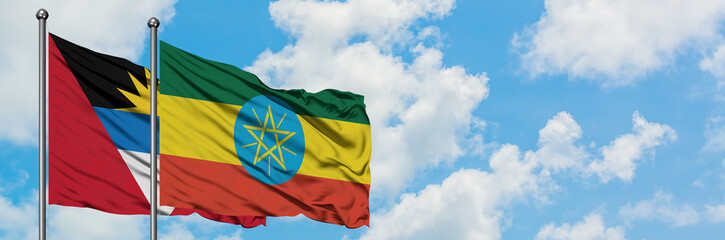 Antigua and Barbuda with Ethiopia flag waving in the wind against white cloudy blue sky together. Diplomacy concept, international relations.