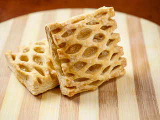 One apple lattice on a wooden board, warm tones, blurred background. Close up, Selective focus. Pastry product.