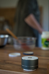 Smart ai speaker with woman cooking in the background. Smart home concept