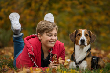Young boy with his dog in autumn landscape