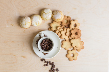 shortbread and coconut biscuits, and a cup of coffee beans on a wooden background