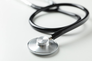 Black stethoscope on white background, close up. Healthcare