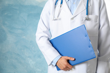Doctor with stethoscope and tablet against blue background, space for text