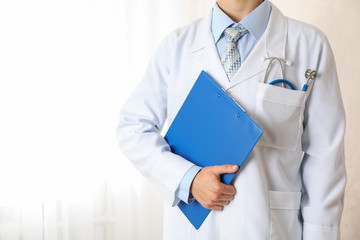 Doctor with blue stethoscope and tablet, space for text