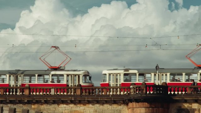 Prague, Czech Republic - September 2019: Bridge with people, tram and fluffy clouds in background. 4K resolution, shallow depth of field.
