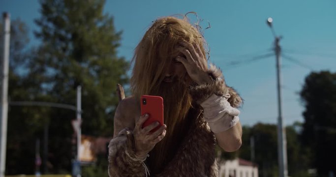 Shot of neanderthal of hunter-gatherers discovering modern device use mobile phone in modern city civilization cro-magnon device evolution future homo sapiens human modern caveman ancient slow motion