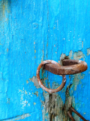 texture of old painted shabby rustic wooden fence made of planks, with rusty nails, hand-forged iron elements, grunge background