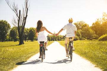 Romantic coupe in love cycling together on a wheat field