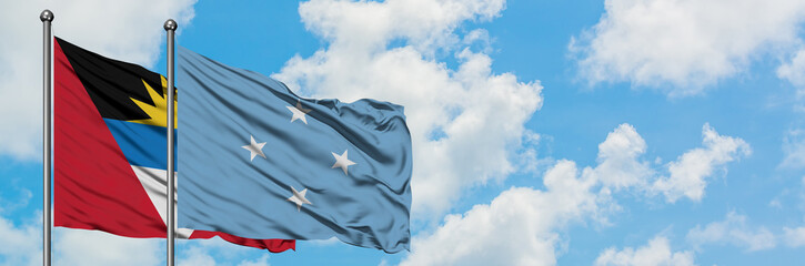 Antigua and Barbuda with Micronesia flag waving in the wind against white cloudy blue sky together. Diplomacy concept, international relations.