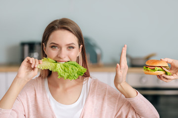 Woman refusing to eat unhealthy food in kitchen. Diet concept