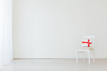 one chair with a gift in the interior of a white empty room