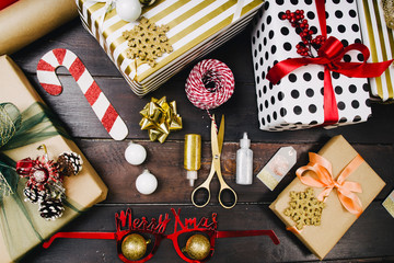 Top view of Gift boxes on black wood background. Presents in craft paper decorated with red ribbon bows. Christmas and other holidays concept, top view with copy space.