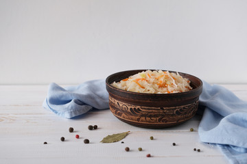 Pickled cabbage with carrot in ceramic bowl. Homemade preserving. Russian traditional food