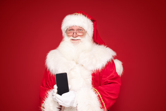Real Santa Claus with mobile phone.