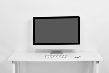 The computer is on a white table on a white background, on the table is a keyboard and a computer...