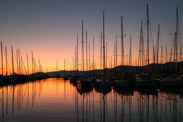 Silhouettes of the sailing boats in the marina during sunset. Relaxation in sunset. Sunset view