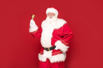 Real Santa Claus on red studio background.