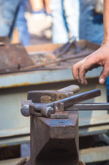 blacksmith performs the forging of hot glowing metal on the anvil