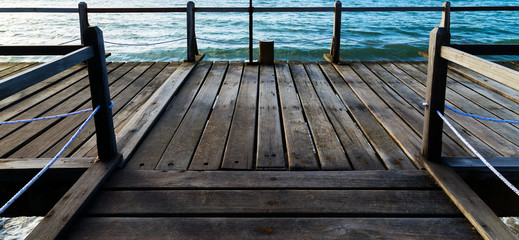 Perspective view wooden pier on the blue sea beach, summer time.
