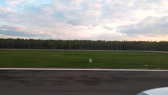 Airplane are taking off from Kaunas airport, Lithuania at morning during beautiful sunset through sun rays in sky. PART 1