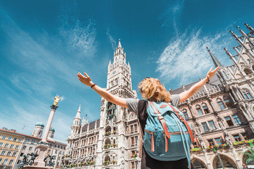 A girl tourist traveler enjoys a Grand view of the Gothic building of the Old town Hall in Munich. Sightseeing and exploration of Germany concept