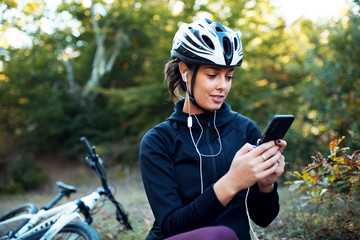 Portrait of female cyclist using smartphone