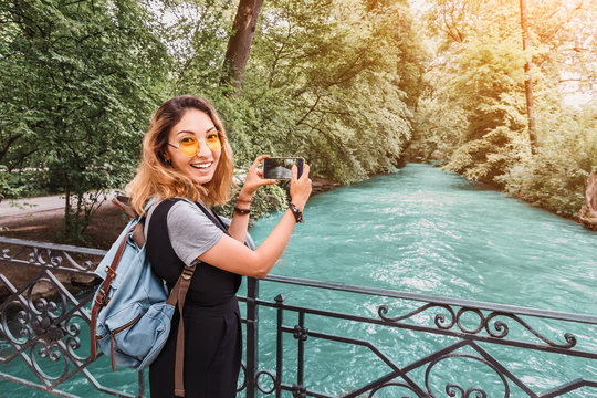 Asian woman making photo of mountain river on her smartphone. Travel blogger concept