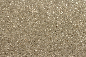 Background of brillant golden natural sand with glitter and sequins.