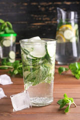 Glass of healthy infused water with ice cubes on table