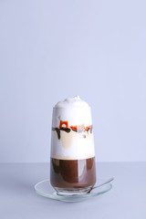 Glass of tasty frappe coffee on grey background