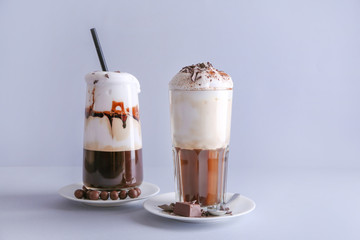 Glasses of tasty frappe coffee on grey background
