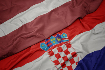 waving colorful flag of croatia and national flag of latvia.