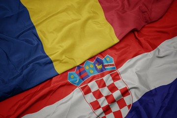 waving colorful flag of croatia and national flag of romania.