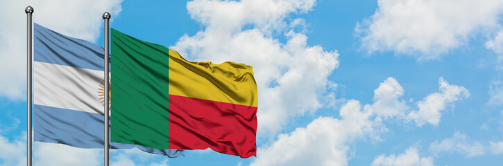 Argentina and Benin flag waving in the wind against white cloudy blue sky together. Diplomacy...