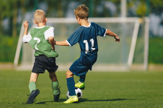 Training and football match between youth soccer teams. Young boys playing soccer game. Hard competition between players running and kicking soccer ball. Final game of football tournament for kids.