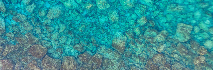 Naklejka na ściany i meble An aerial view of the beautiful Mediterranean sea, where you can se the rocky textured underwater corals and the clean turquoise water of blue lagoon Agia Napa