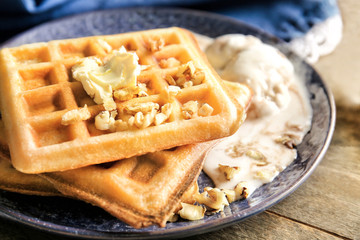 Tasty waffles and ice cream on plate, closeup