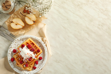 Plate with tasty waffles, ice cream and berries on table