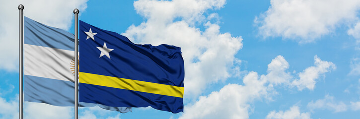 Argentina and Curacao flag waving in the wind against white cloudy blue sky together. Diplomacy concept, international relations.