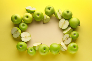 Frame made of ripe apples on color background