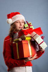 Picture of cheerful santa helper girl with many gifts box isolated on gray background