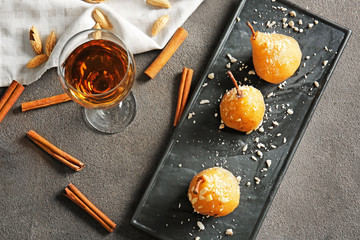 Plate with tasty cooked pears an d glass of drink on table