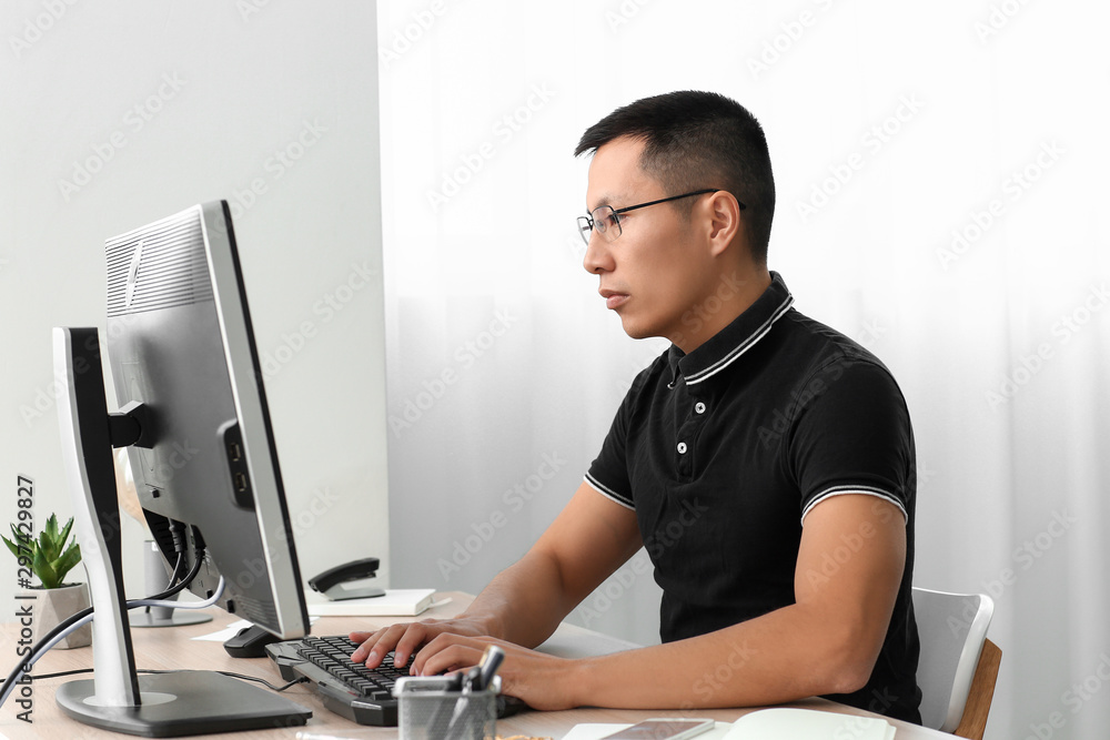 Poster asian programmer working on computer in office
