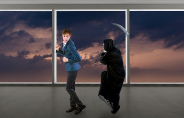Man in a Halloween grim reaper ghost costume chasing, mocking and making fun of scared businessman...