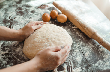 Making dough by female hands on wooden table background. Cooking concept. Lovely female hands.