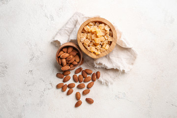 Bowls with dried fruit and almond nuts on light background