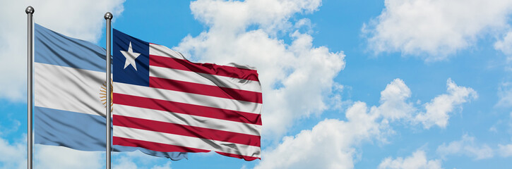 Argentina and Liberia flag waving in the wind against white cloudy blue sky together. Diplomacy concept, international relations.