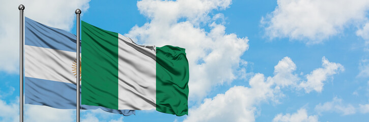 Obraz premium Argentina and Nigeria flag waving in the wind against white cloudy blue sky together. Diplomacy concept, international relations.