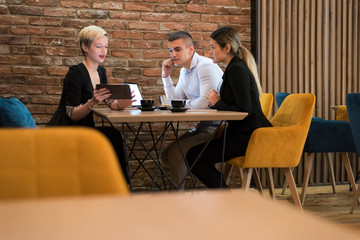 Group of a young business people brainstorming and discussing business plan on meeting at sunny...